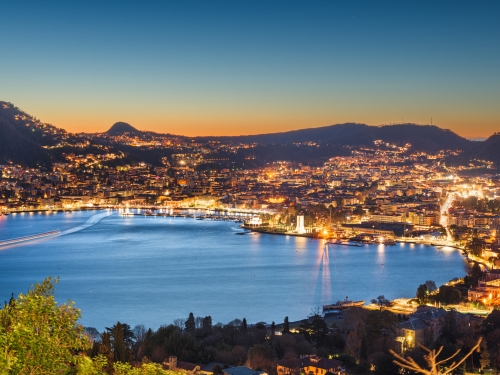 Città di Como illuminata di sera vista dall'alto