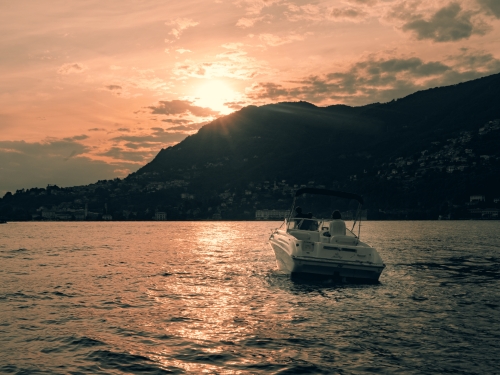 Barca durante un tour di Lario Como Boat al tramonto sul lago di Como