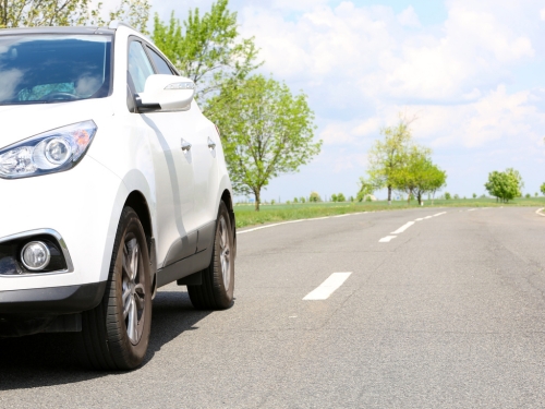 Auto bianca percorre una strada 