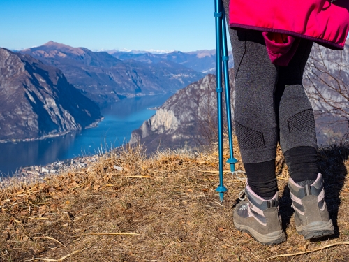 Persona con abbigliamento da trekking lungo i sentieri del Lago di Como.