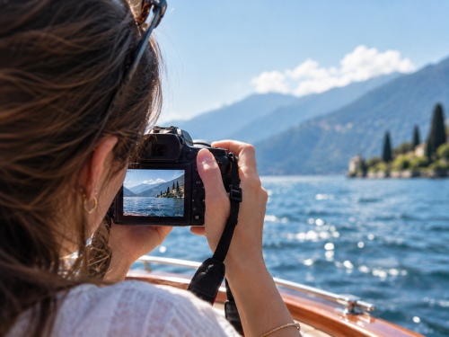 Donna fotografa il paesaggio del lago durante una navigazione privata