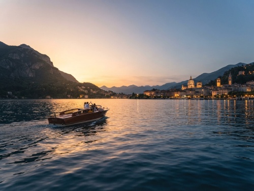 Veduta panoramica del ramo di Como al tramonto con barca in legno e città illuminata
